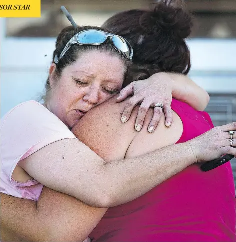  ?? NICK WAGNER / AUSTIN AMERICAN-STATESMAN VIA THE ASSOCIATED PRESS ?? Carrie Matula embraces a woman after a shooting left dozens dead and wounded at the First Baptist Church in Sutherland Springs, Tex., on Sunday.