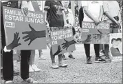  ?? DENISE CATHEY/THE BROWNSVILL­E HERALD ?? People hold signs that read “families belong together” during a vigil this week in Brownsvill­e, Texas, to advocate against the separation of migrant families at the border.