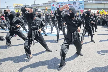  ?? AFP ?? Iraqi Shia fighters from the Iran-backed armed group march during a military parade marking Al-Quds Internatio­nal Day in Baghdad.