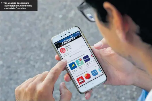  ?? GABRIEL UTIEL ?? ▶▶ Un usuario descarga la aplicación de Airbnb en la ciudad de Castellón.