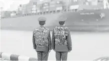  ?? Chinatopix via Associated Press ?? Chinese border police officers watch the arrival of a container ship at a port in Qingdao in eastern China's Shandong province.