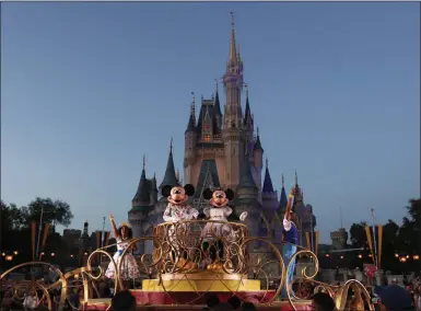  ?? JOHN RAOUX — THE ASSOCIATED PRESS ?? On Jan. 15, Mickey and Minnie Mouse perform during a parade as they pass by the Cinderella Castle at the Magic Kingdom theme park at Walt Disney World in Lake Buena Vista, Fla. Florida tourism officials say cases of the new coronaviru­s are having little visible impact on the state’s biggest industry so far. Disney officials said in a statement that extra hand sanitizers were being placed throughout its four parks and more than two dozen hotels.