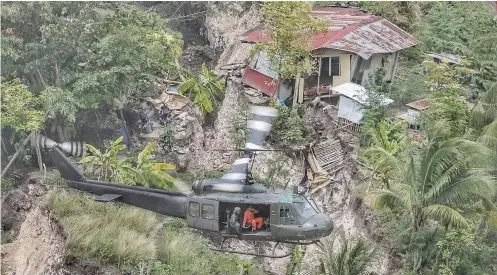  ?? SUNSTAR FOTO / ALEX BADAYOS ?? AERIAL SURVEY. A helicopter conducts an aerial survey on the extent of the Naga landslide on Sept. 20, 2018.