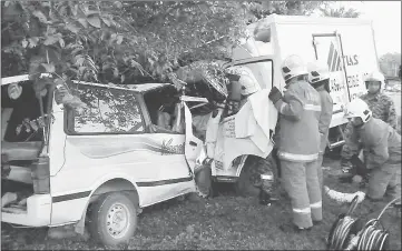  ??  ?? Bomba personnel working to extricate the victims from the van. — Bernama photo