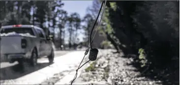  ?? ALYSSA POINTER / ALYSSA.POINTER@AJC.COM ?? A downed power line rests on the sidewalk along Holly Springs Road NE in Marietta on Monday. Cobb agencies were working Monday to restore power and clean debris for many residents.