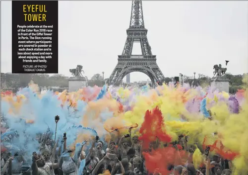  ??  ?? People celebrate at the end of the Color Run 2018 race in front of the Eiffel Tower in Paris. The 5km running event where participan­ts are covered in powder at each check station and is less about speed and more about enjoying a day with friends and...