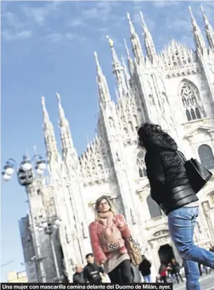  ??  ?? Una mujer con mascarilla camina delante del Duomo de Milán, ayer.