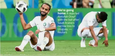  ??  ?? We’re going home: A dejected Abdullah Otayf with the ball after Saudi Arabia’s narrow loss to Uruguay. — Reuters