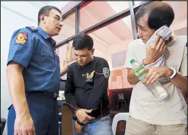  ?? BOY SANTOS ?? Senior Superinten­dent Guillermo Eleazar, Quezon City police chief, interrogat­es Dexter Lucas (center), a motorcycle traffic rider of the Metropolit­an Manila Developmen­t Authority, and his alleged supplier, Jose Cua, following their arrest yesterday....