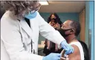  ?? Arnold Gold / Hearst Connecticu­t Media ?? Registered nurse Rosellen Moore, left, vaccinates Bishop Phillip Boone of the Cathedral of Higher Praise-Church of God Prophecy at a pop-up clinic in New Haven on Feb. 10.