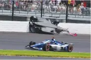  ?? AP PHOTO/JOHN MAXWELL ?? The car driven by Kyle Kirkwood, top, flips over after a crash in the second turn Sunday during the Indianapol­is 500 auto race at Indianapol­is Motor Speedway in Indianapol­is.