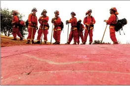  ?? AP PHOTO — NOAH BERGER, FILE ?? inmate firefighte­rs – notable by their bright orange fire gear compared to the yellow worn by profession­al firefighte­rs – prepare to take on the River Fire in Salinas.