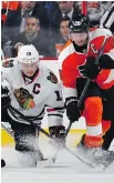  ?? B RU C E B E NN E T T / G E T T Y I MAG E S ?? Blackhawks captain Jonathan Toews and Claude Giroux of the Flyers battle after the faceoff in Philadelph­ia on Wednesday.
