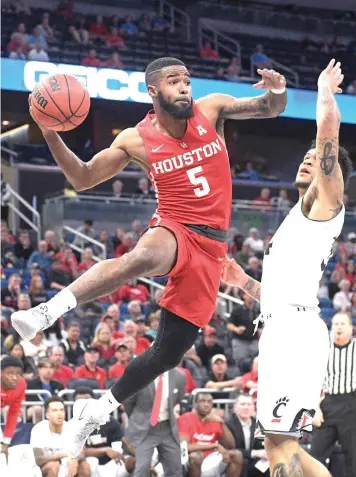  ?? Phelan M. Ebenhack/The Associated Press ?? ■ Houston guard Corey Davis Jr. passes the ball in front of Cincinnati guard Jarron Cumberland, right, during the first half of the American Athletic Conference championsh­ip Sunday in Orlando, Fla. Houston lost, 56-55, but drew the sixth seed in the...