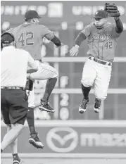  ??  ?? Carlos Correa, left, and George Springer celebrate the Astros’ 1-0 victory over the Tigers on Friday.