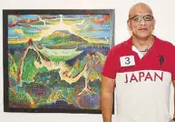  ??  ?? Jommel Bañez with the artworks of his uncle Bienvenido Bañez, “Mandaranga­n God of Mt. Apo” (left) and “Bagobo Triad” (right)