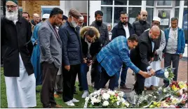  ?? ?? TRIBUTE: Members of the town’s Muslim community laying flowers yesterday