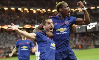  ?? ANDERS WIKLUND/TT VIA AP ?? Manchester United’s Henrikh Mkhitaryan (left), celebrates scoring with teammate Paul Pogba during the Europa League soccer final match between Ajax and Manchester United at the Friends Arena in Stockholm, Sweden, on Wednesday.