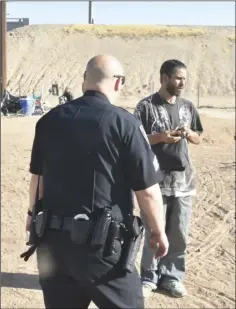  ??  ?? Patrol Sgt. James Thompson of the El Centro Police Department talks to a homeless man staying at a camp near Interstate 8. PHOTO TOM BODUS