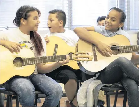  ?? Brian van der Brug
Los Angeles Times ?? MUSIC STUDENTS practice guitar in Bladimir Castro’s class at Carlos Santana Arts Academy in North Hills. Principal Leah BassBaylis, a former dancer, turned to business and personal contacts to provide classes that she could not offer with limited...