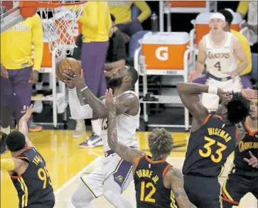  ?? Luis Sinco Los Angeles Times ?? LAKERS forward LeBron James, who scored 19 points, draws four Golden State Warriors defenders en route to a basket in the second quarter of Sunday’s 117-91 win by Los Angeles at Staples Center.