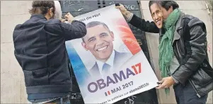  ?? AP PHOTO ?? Two organizers of a online petition wearing masks of former U.S. President Barack Obama stick a campaign poster on a wall who reads “yes we can” in Paris, Friday. An online petition urging Barack Obama to join the French presidenti­al race has attracted...