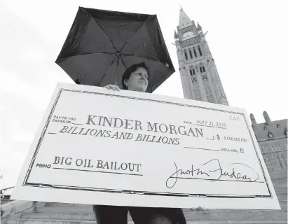  ?? JUSTIN TANG, THE CANADIAN PRESS ?? A woman protests the proposed Trans Mountain pipeline project on Parliament Hill on May 22. If the federal government bails out the pipeline’s expansion, it’s largely Justin Trudeau’s fault, Gwyn Morgan writes.