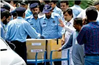  ?? AP ?? Police officers stand guard near boxes carrying evidence in the anti-graft probe, as it arrived at the Supreme Court in Islamabad on Monday. —