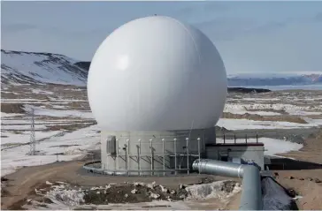  ??  ?? Photo ci-dessus :
Une antenne sur la base aérienne de Thulé, la base américaine la plus septentrio­nale, située sur la côte nord-ouest du Groenland, le 26 juillet 2016. Elle n’accueille plus qu’une centaine de militaires américains (après en avoir compté jusqu’à 10 000 pendant la guerre froide), mais continue d’assurer des missions d’alerte aux missiles balistique­s, de surveillan­ce spatiale, ainsi que de commandeme­nt et contrôle par satellite. (© DoD)