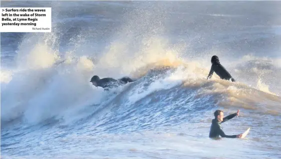  ?? Richard Austin ?? Surfers ride the waves left in the wake of Storm Bella, at Lyme Regis yesterday morning