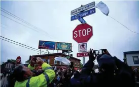  ?? AARON LAVINSKY/STAR TRIBUNE VIA AP ?? A new George Perry Floyd Square sign is unveiled in front of hundreds of community members May 25 in Minneapoli­s.