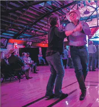  ??  ?? COUPLES DANCE as Marty Stuart & His Fabulous Superlativ­es play. Besides concerts, Cain’s has also bbeen the site of mud-wrestling matches and a circus sideshow.