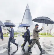  ?? ?? People wearing protective face masks walk amid concerns over COVID-19, Pyongyang, North Korea, May 15, 2020.