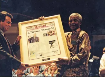  ?? Picture: MIKE HOLMES ?? MADIBA MOMENT: At a civic function to mark the 150th anniversar­y of The Herald in 1995, former editor Ric Wilson gave Nelson Mandela a framed front page recording his inaugurati­on the previous year