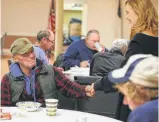  ??  ?? “Wild” Bill, who didn’t give his last name, greets volunteer Rachel DeMarco before eating a warm meal at Bethany United Methodist Church on Eisenhauer Road.