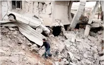  ??  ?? A Syrian man walks amid ruins following bombardmen­t a day earlier in the opposition-controlled town of Misraba in the Eastern Ghouta region on the outskirts of Damascus. (AFP)