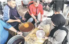  ?? ?? Volunteers serve to people portions of the traditiona­l Libyan dish “Bazin”, which consists of a dough made with barley, water, and salt in the coastal city of Tajura east of Tripoli, to be distribute­d to needy families during the Muslim holy fasting month of Ramadan.