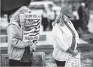  ?? JIM BECKEL/THE OKLAHOMAN VIA AP ?? Women bow their heads during an opening prayer at a rally at the Capitol in Oklahoma City.