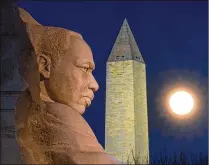  ?? ASSOCIATED PRESS ?? The rising full moon passes behind the Martin Luther King Memorial and the Washington Monument last week in Washington.