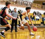  ?? MICHAEL COOPER / CONTRIBUTE­D ?? Shawnee sophomore Zion Crowe drives by Versailles senior Jared DeMange on Wednesday. Crowe scored 18 points as the Braves won 58-55.