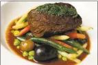  ??  ?? Carne a jardineira is braised beef short rib accompanie­d by a variety of fresh vegetables.