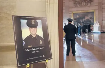  ?? BRENDAN SMIALOWSKI/AP ?? A placard in the Capitol Rotunda displays a photograph last month of Capitol Police Officer Brian Sicknick, who died after clashing with rioters in the Jan. 6 attack on the building. He died the next day from his injuries.