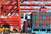  ?? ?? Trucks wait to load containers at a container terminal in Rizhao, east China’s Shandong Province, March 28, 2022. In the first three quarters, China’s GDP increased 3 percent year on year, 0.5 percentage points faster than that in the first half of 2022, according to the National Bureau of Statistics (NBS) data.