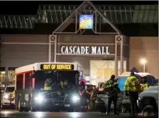  ??  ?? Emergency personnel stand in front of an entrance to the Cascade Mall at the scene of a shooting where several people were killed Friday in Burlington, Wash. AP PHOTO