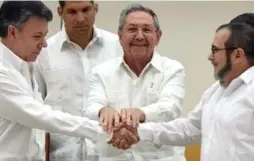  ?? LUIS ACOSTA/AFP/GETTY IMAGES ?? Colombian President Juan Manuel Santos, left, FARC leader Timoleon Jimenez, right, and Cuban President Raul Castros shake hands in Havana last September.