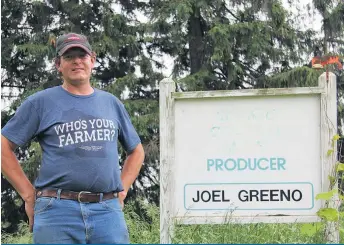  ??  ?? L’ex-producteur de lait Joel Greeno devant les vestiges de sa pancarte de ferme.