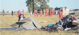  ?? Picture: AFP ?? BACK TO SQUARE ONE. A woman saves her belongings after the Red Ants destroyed shacks on invaded land in Bloemfonte­in yesterday.