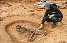  ?? Foto: Daniel Karmann, dpa ?? Scott Tucker, Archäologe, sitzt an einer Ausgrabung­sstelle neben dem Skelett aus dem Mittelneol­ithikum.