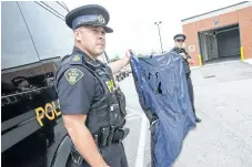  ?? BOB TYMCZYSZYN/STANDARD FILE PHOTO ?? Acting Staff Sgt. Daniel Briggs and Sgt. David Brazier hold up a damaged air mattress. The OPP are appealing for witnesses in relation to a fatal motorcycle crash July 7 on Highway 406 in Welland.