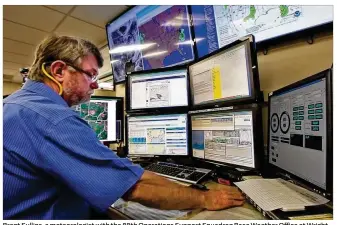  ?? TY GREENLEES / STAFF ?? Brent Sullins, a meteorolog­ist with the 88th Operations Support Squadron Base Weather Office at WrightPatt­erson Air Force Base, prepares a weather briefing for the 445th Airlift Wing crew. The office functions much like the National Weather Service but...